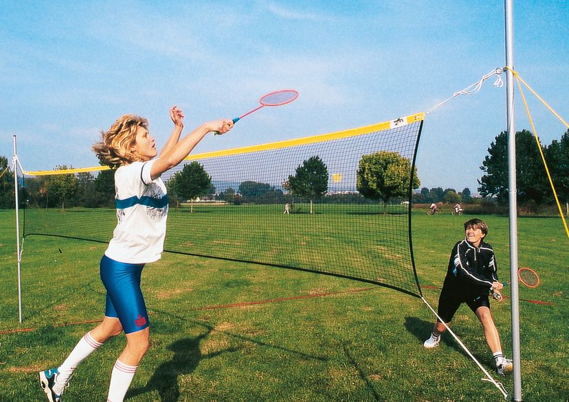 Freizeit-Badmintonnetz mir 2 Spielerinnen auf Rasen